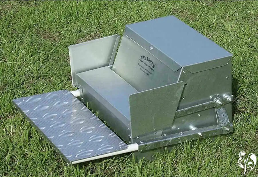 Grandpa's automatic chicken feeder when new, on grass.