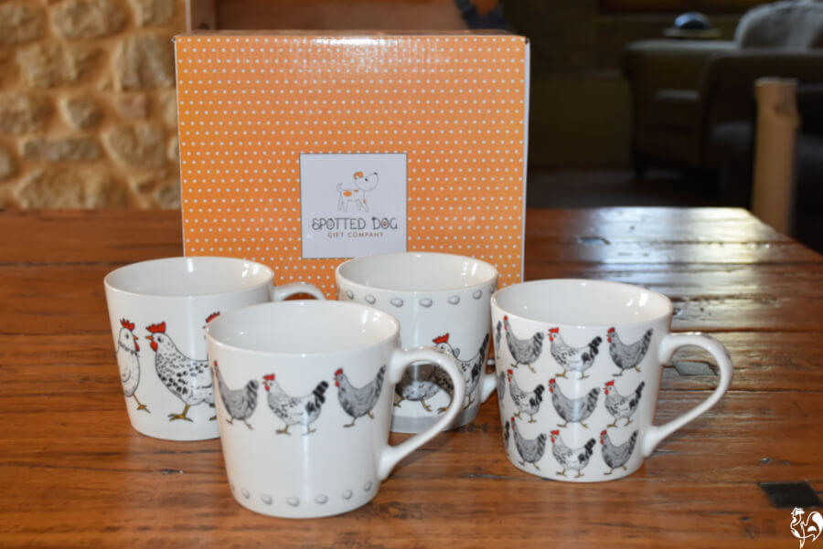 The chicken themed coffee mugs set in front of their presentation box.