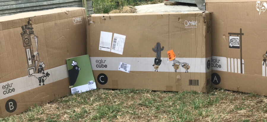 Eglu Cube three flat packs laid out on my garden.