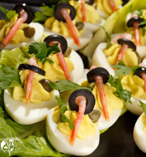 Deviled eggs with olives and shrimp tails.