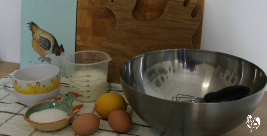 Ingredients for a simple pancake recipe. Ingredients for a simple pancake recipe:eggs, milk, sugar, lemon on a worksurface.