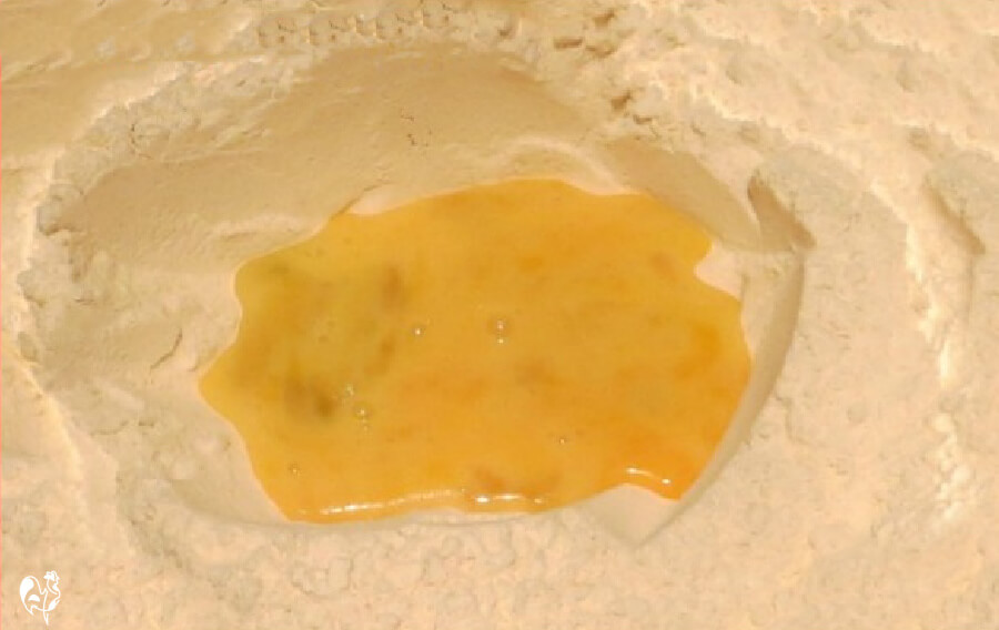 Homemade pancake batter - no unecessary ingredients! An egg in the centre of flour making the pancake batter.